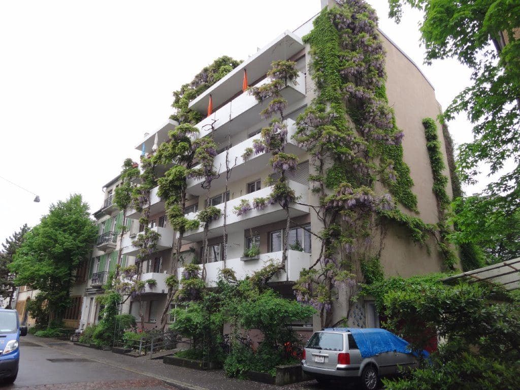 Begrüntes Mehrfamilienhaus mit Kletterpflanzen an der Fassade