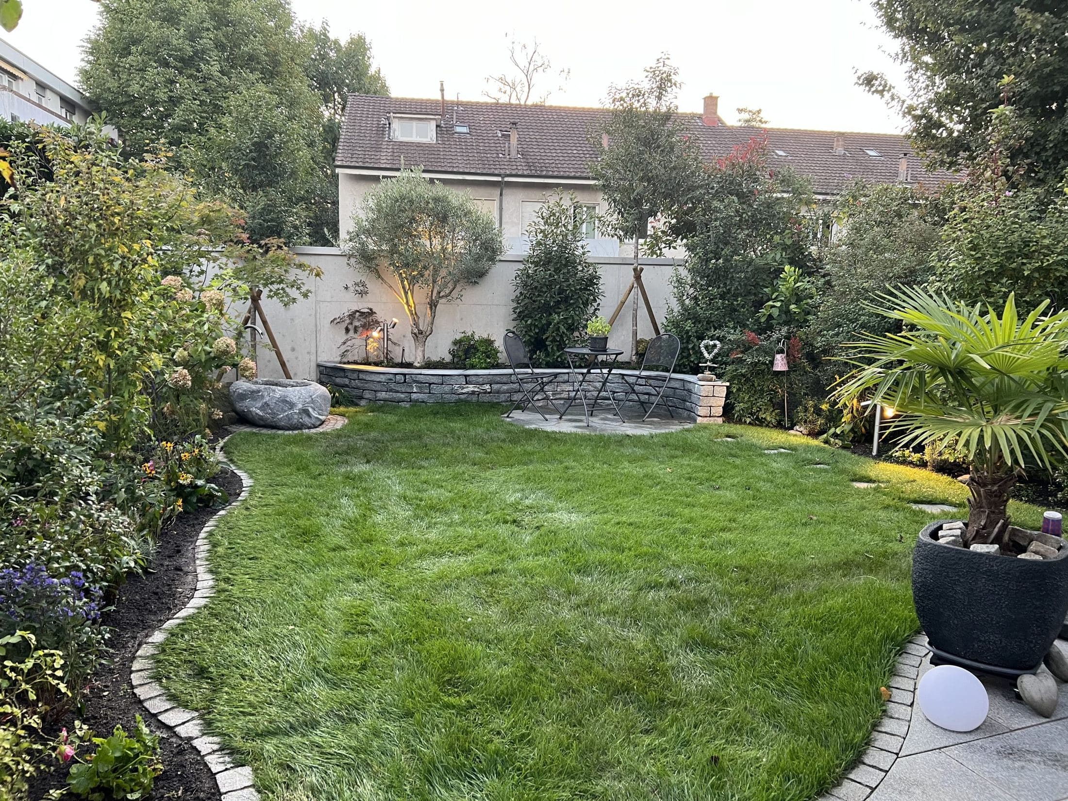 Neu angelegter Garten mit geschwungener Einfassung, Rasen und Sitzplatz