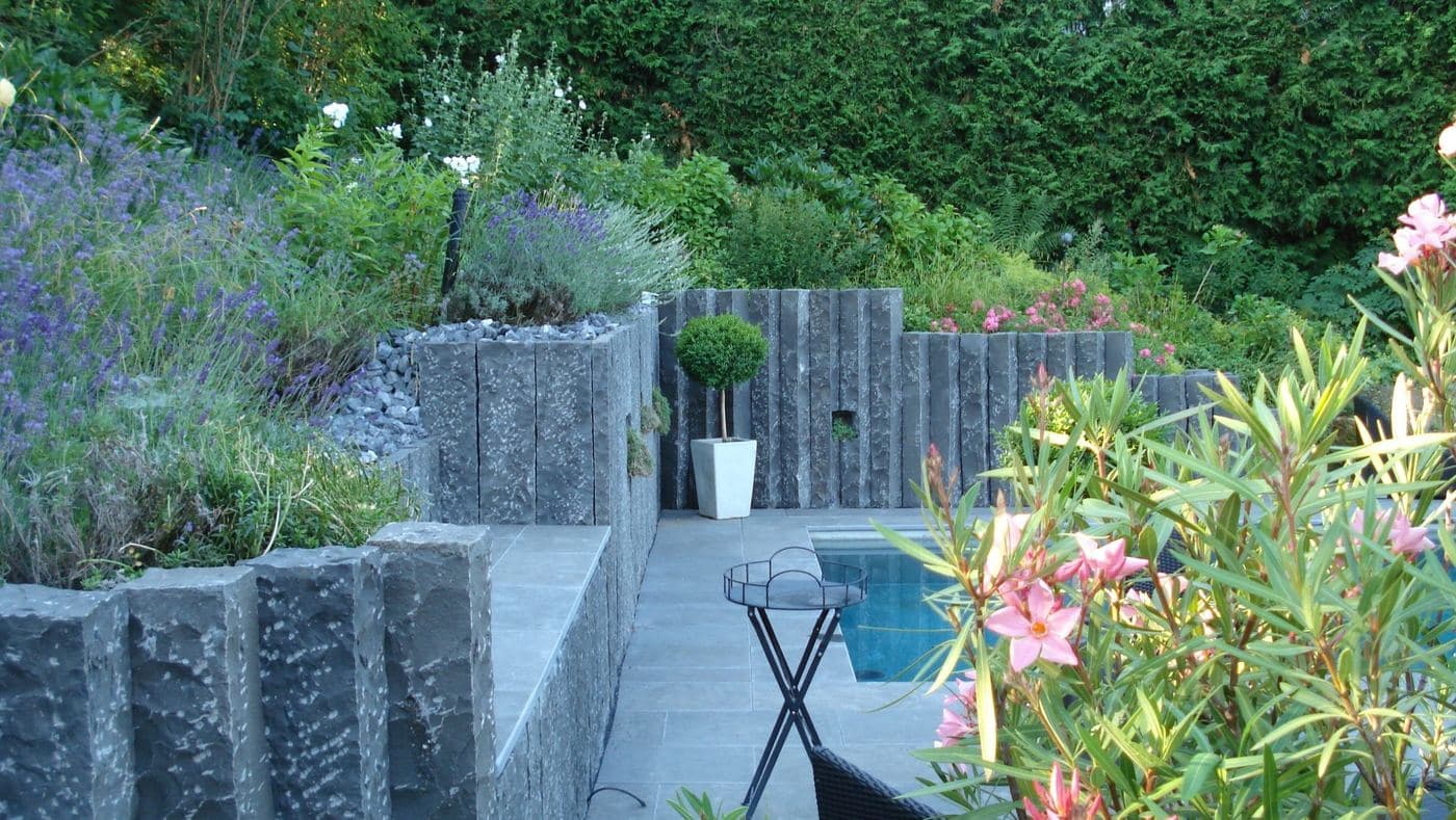 Terrasse mit Natursteinstelen und blühendem Oleander